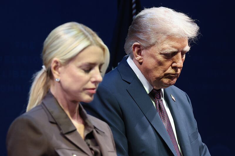 President Donald Trump bows his head in prayer alongside Attorney General Pam Bondi at the Museum of the Bible on September 8, 2025 in Washington, D.C.