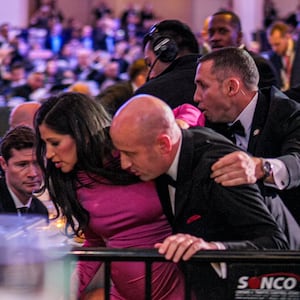 Secretary of War Pete Hegseth (L) stands as White House Deputy Chief of Staff for Policy Stephen Miller and his wife Katie Miller (C) are taken out of the ballroom by security agents during a shooting incident at the annual White House Correspondents Association Dinner at the Washington Hilton on April 25, 2026 in Washington, DC.