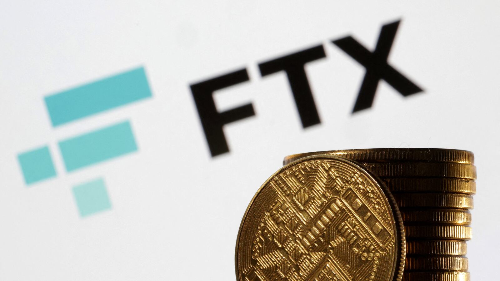 An image displaying the FTX logo and fake gold tokens.