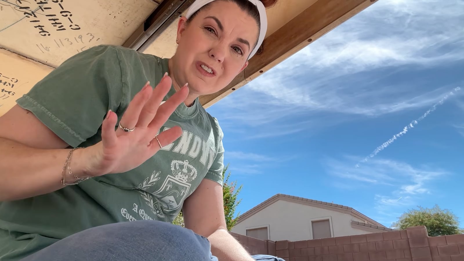 A woman hides under a table in her backyard.