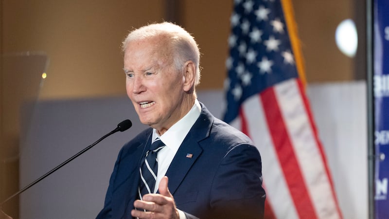 Former President Joe Biden speaks at a podium in front of the U.S. flag