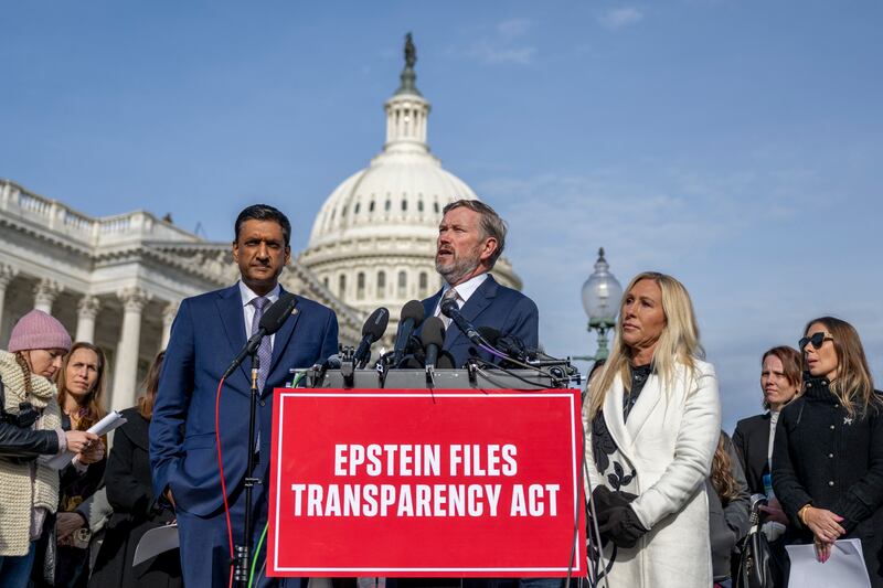 Rep. Thomas Massie (center) with Rep. Ro Khanna (left) and Rep. Marjorie Taylor Greene (right) speak during a news conference surrounded by Epstein survivors ahead of the vote on the Epstein Files Transparency Act on November 18.