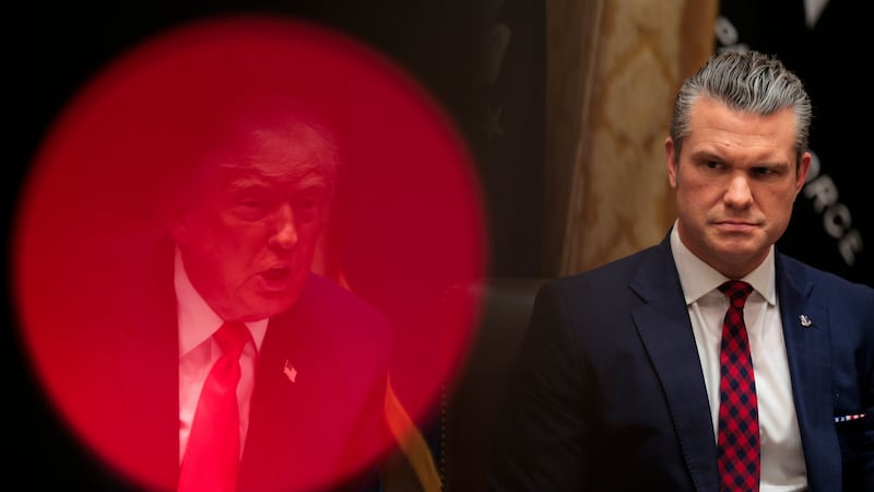 U.S. President Donald Trump (L) speaks as U.S. Secretary of War Pete Hegseth looks on.