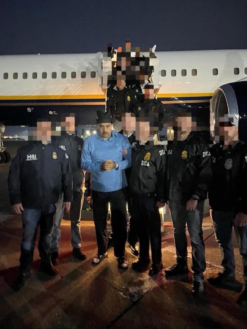 DEA agents with faces blurred surrounding Nicolas Maduro at the bottom of a plane's steps