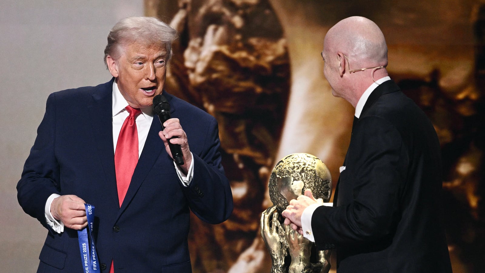 President Donald Trump speaks as he receives the inaugural FIFA Peace Prize alongside FIFA President Gianni Infantino during the draw for the 2026 FIFA Football World Cup in Washington, DC, on December 5, 2025.