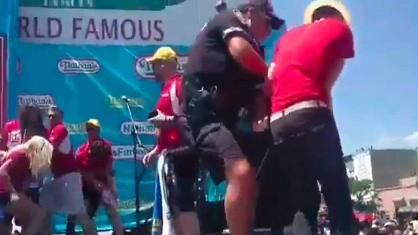 articles/2016/07/05/watch-protesters-dump-fake-blood-on-hot-dog-eating-contestants/160705-Place-nathans-hot-dog-protest-fake-blood-Tease_pl3ynx