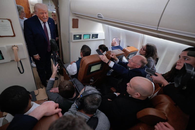 U.S. President Donald Trump speaks to reporters on board Air Force One