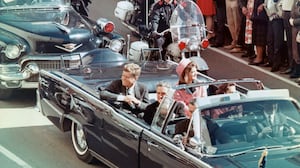 US President John F Kennedy, First Lady Jacqueline Kennedy, Texas Governor John Connally, and others smile at the crowds lining their motorcade route in Dallas, Texas, on November 22, 1963.
