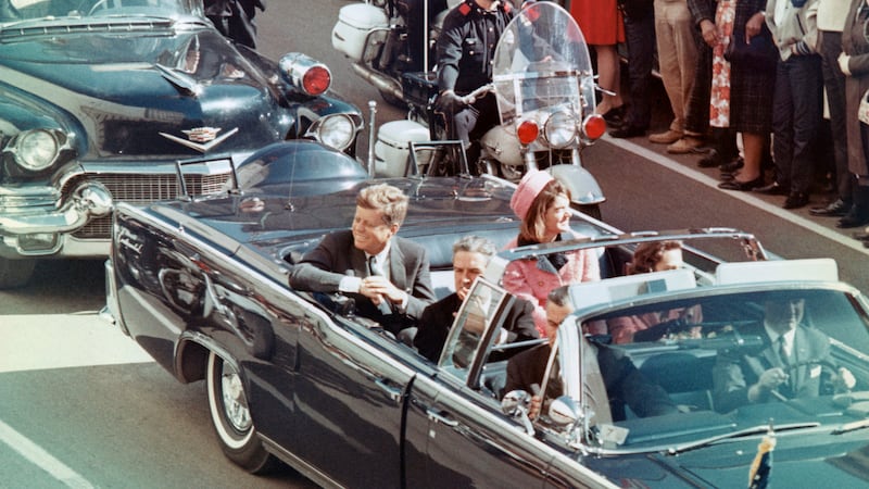 US President John F Kennedy, First Lady Jacqueline Kennedy, Texas Governor John Connally, and others smile at the crowds lining their motorcade route in Dallas, Texas, on November 22, 1963.