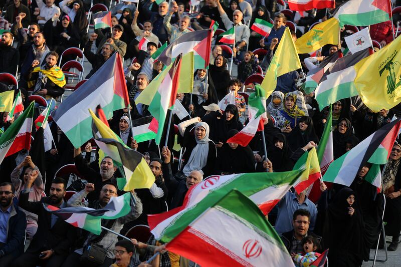 People follow the speech of Hezbollah Secretary General Hassan Nasrallah in Tehran.