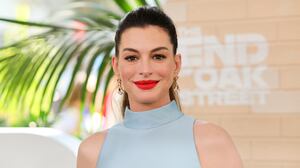 Anne Hathaway wears blue halter top and red lipstick to attend the world premiere of Warner Bros.' "The End Of Oak Street" at Warner Bros. Studios on August 9, 2026, in Burbank, California.