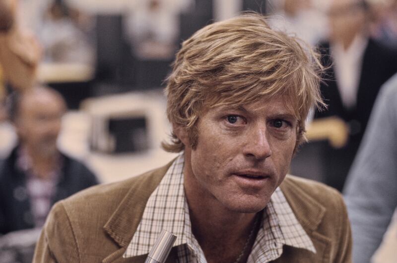 American actor Robert Redford, wearing a brown corduroy blazer over a checked shirt, in a recreation of The Washington Post's offices, in a publicity still for 'All the President's Men', filmed at Burbank Studios in Burbank, California, 1976. The political thriller based on the Watergate scandal, directed by Alan J Pakula, starred Redford as Bob Woodward. (Photo by Michael Ochs Archives/Getty Images)