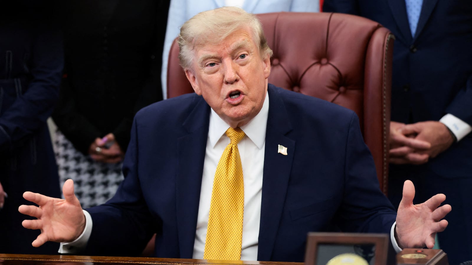 U.S. President Donald Trump answers questions from the media after signing an executive order establishing the President's Military Spouse Commission to be chaired by Jennifer Rauchet, wife of Secretary of Defense Pete Hegseth, in the Oval Office at the White House in Washington, D.C., U.S., August 3, 2026.