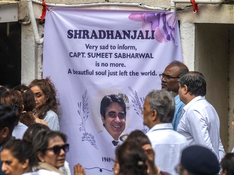 MUMBAI, INDIA - JUNE 17: Relatives and neighbors gather outside the Powai residence as the mortal remains of captain Sumeet Sabharwal, who died in the ill-fated Air India flight, arrives home on June 17, 2025 in Mumbai, India. (Photo by Satish Bate/Hindustan Times via Getty Images)