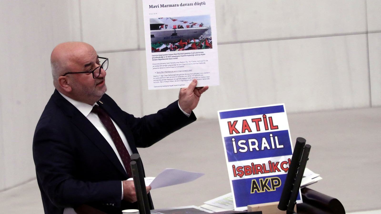 Turkey's opposition Felicity Party (Saadet) lawmaker Hasan Bitmez makes a speech at a stand with a placard, criticizing the government's policy towards Israel, at the Turkish parliament in Ankara, Turkey