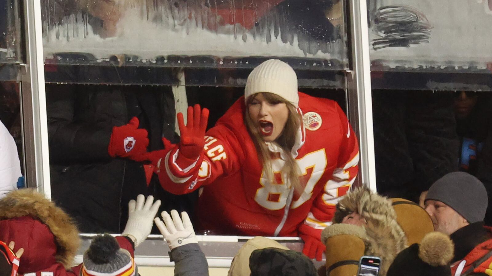 Taylor Swift high-fiving some fans.
