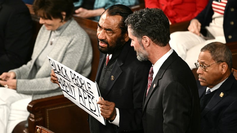 Representative Al Green, a democrat from Texas, holds a sign reading "Black People Aren't Apes" as he is escorted out during US President Donald Trump's State of the Union address in the House Chamber of the US Capitol in Washington, DC, on Feb. 24, 2026.