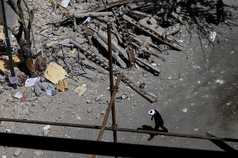 A cleric walks near a residential building damaged by a strike on March 4, in Tehran, Iran, April 14, 2026. REUTERS/Thaier Al Sudani     TPX IMAGES OF THE DAY