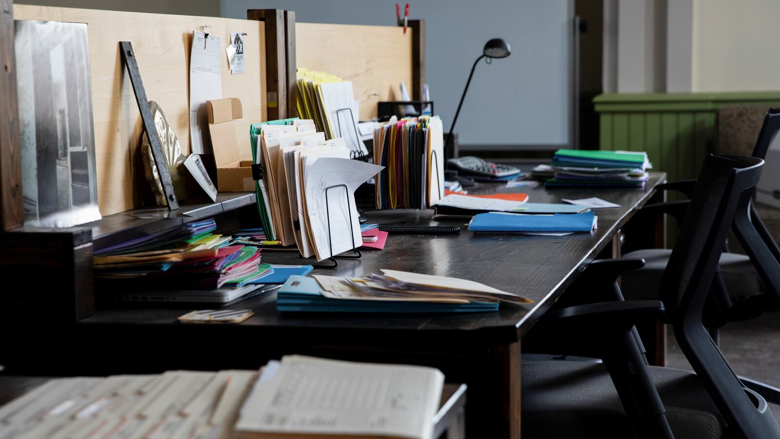 An empty office desk full of items and files
