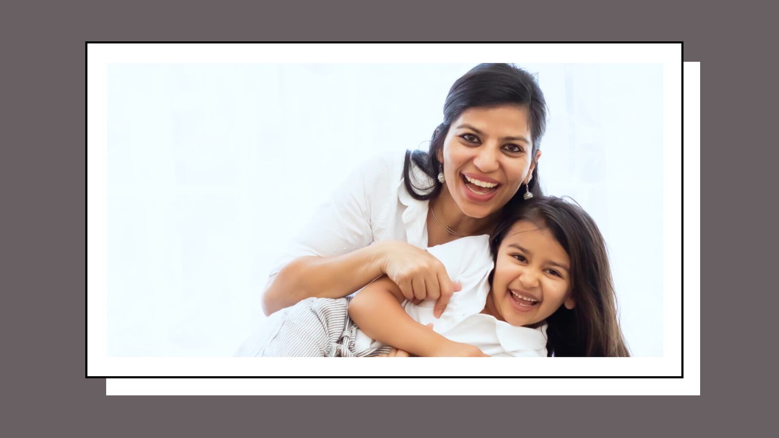 Smiling mother embracing her young daughter in a bright, joyful setting