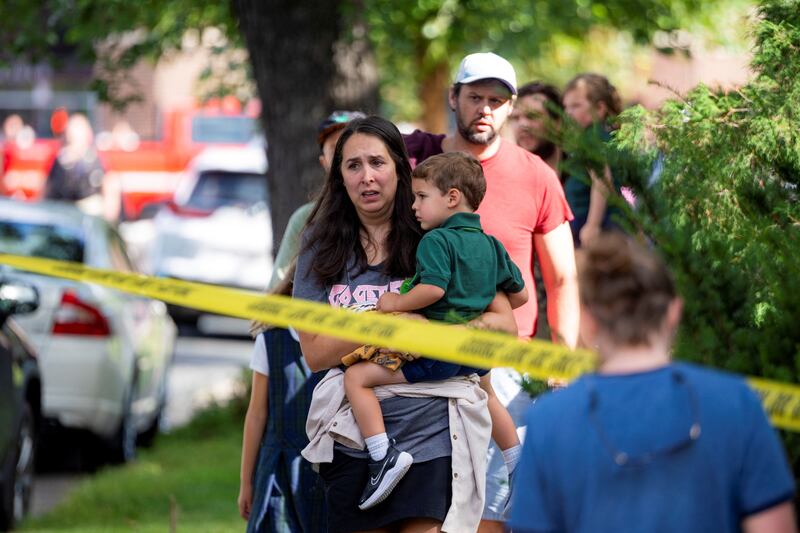 Families reunite outside the police barricades near Annunciation Church’s school on Wednesday morning. The school hosts children from Pre-K to eighth grade.