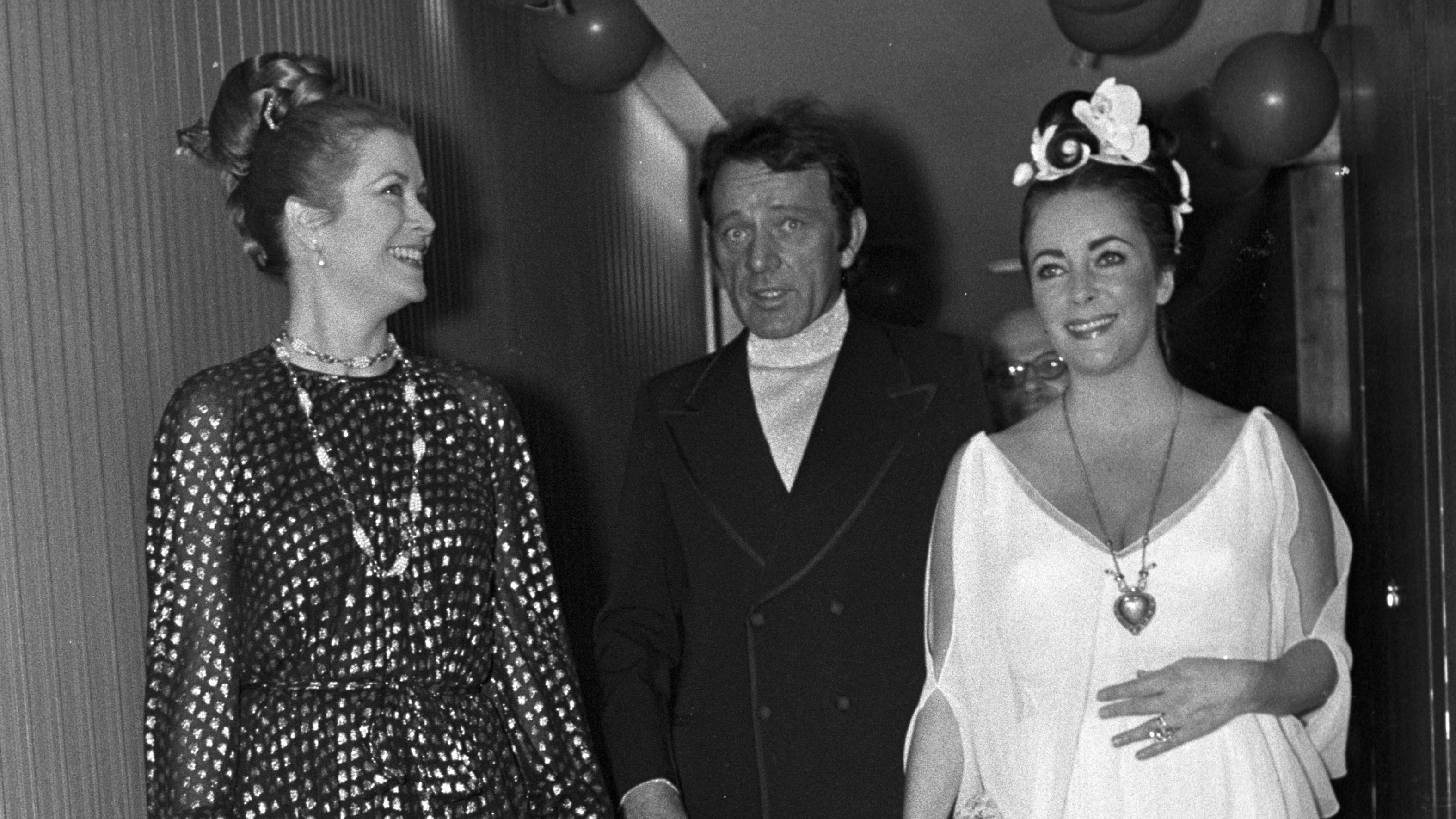 Grace Kelly, Richard Burton, and Elizabeth Taylor celebrate Taylor's fortieth birthday. 

Taylor wears the "Taj Mahal" diamond necklace.