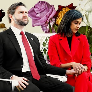 JD Vance and Usha Vance seated holding hands with wilting flowers behind them