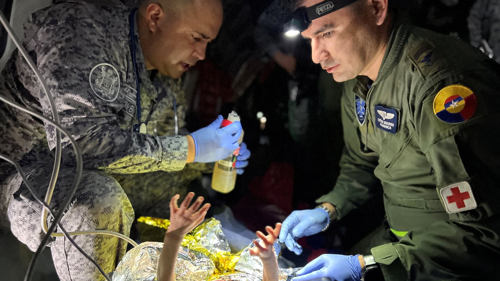 Soldiers of the Colombian Air Force give medical attention inside a plane to the surviving children of a Cessna 206 plane crash in the thick jungle, while they are transferred to Bogota by air in San Jose del Guaviare, Colombia, June 9, 2023.