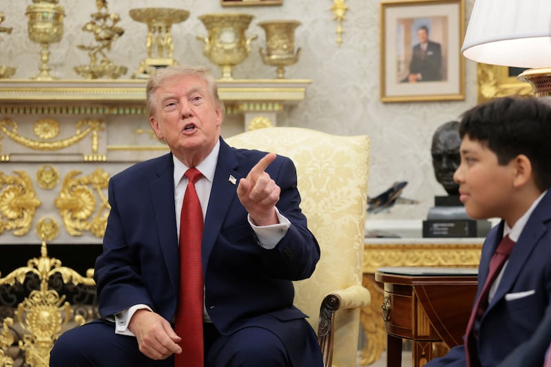 U.S. President Donald Trump speaks as he sits next to Nathaniel Rai, a child saved by 16-year-old lifeguard Ryder Williams off the coast of Santa Cruz, California, last month, while hosting him and Williams in the Oval Office, at the White House in Washington, D.C., U.S., August 17, 2026. REUTERS/Kylie Cooper
