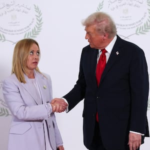 U.S. President Donald Trump and Italian Prime Minister Giorgia Meloni shake hands as they pose for a photo during a world leaders' summit on ending the Gaza war on October 13, 2025 in Sharm El-Sheikh, Egypt.