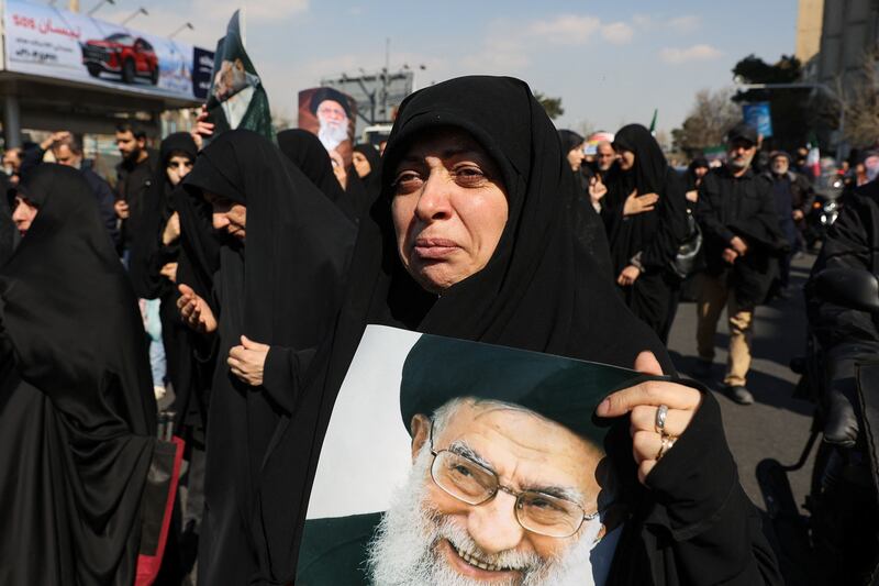 A demonstrator holds an image of Iran's late Supreme Leader, Ayatollah Ali Khamenei, during a protest rally in Tehran on March 6, 2026.
