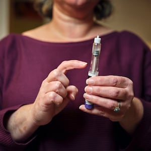 Woman holding a GLP-1 shot of Ozempic