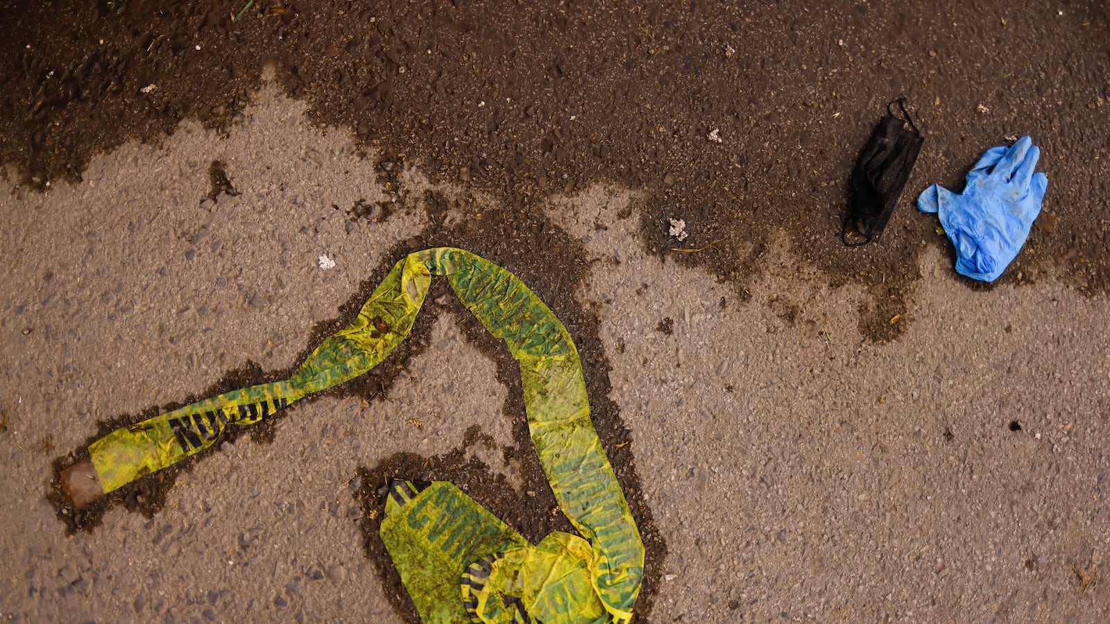 A caution tape, a glove and a face mask are seen on the ground after a fire broke out late on Monday at the National Migration Institute (INM) building, in Ciudad Juarez, Mexico.