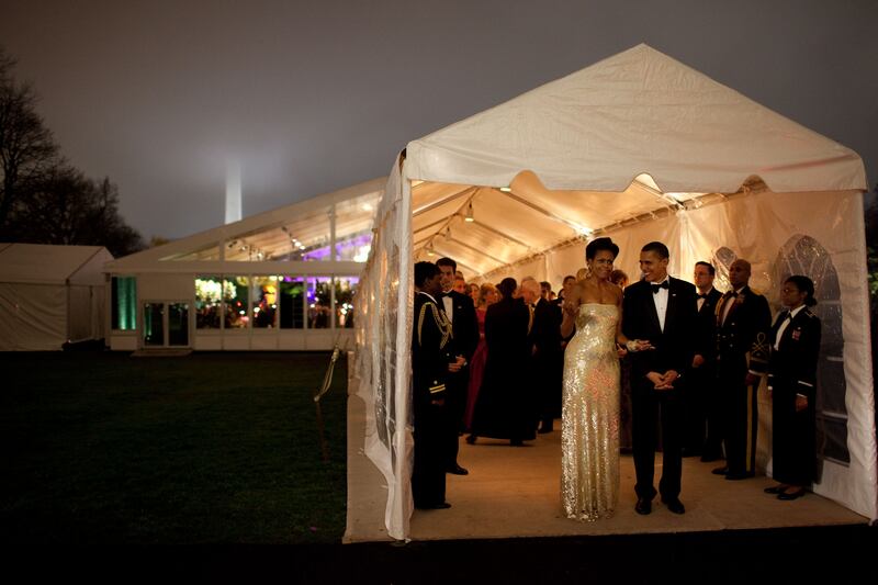 President Barack Obama (R) and first lady Michelle Obama share a laugh while leaving the State Dinner that was held in a tent on the South Lawn of the White House November 24, 2009 in Washington, DC.
