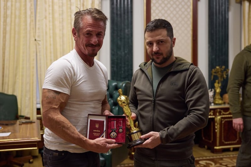 Sean Penn (L) meets Ukrainian President Vladimir Zelensky (R) as he hands over his own Oscar statuette 2022