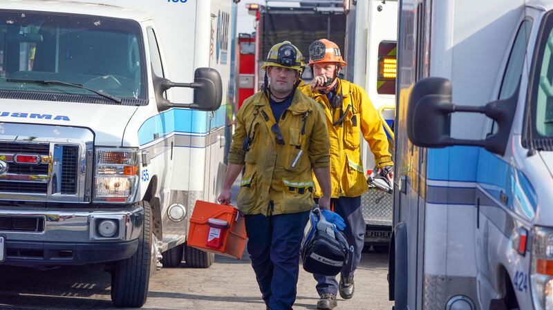 CUDAHY, CA - JANUARY 14: Firefighter/paramedics walk between a group of ambulances after 26 people, 17 children and 9 adults, were treated for jet fuel exposure at Park Avenue Elementary School in Cudahy on Tuesday, Jan. 14, 2020. A jet returning to LAX dumped its fuel over the neighborhood and the school. Affected people at the school were treated for skin and eye irritation. No patients were transported to hospitals.