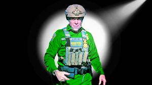 A photo illustration of Border Patrol Cmdr. Gregory Bovino in a spotlight.