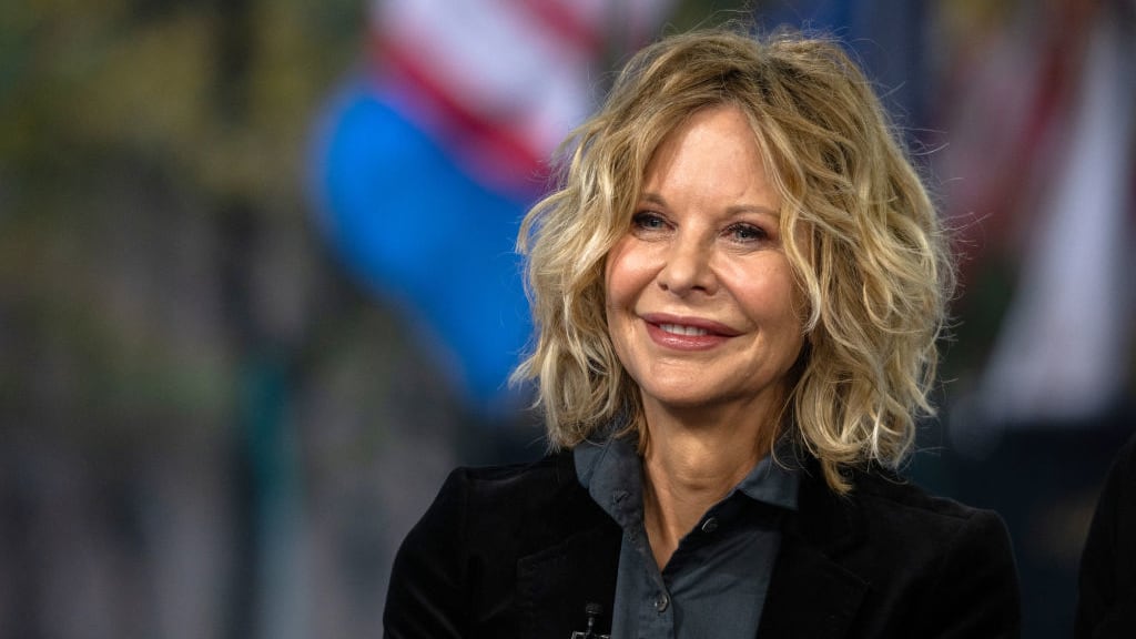 Meg Ryan smiles on a TV set.