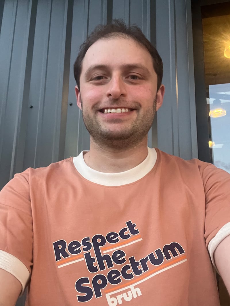 A smiling man in a t-shirt saying "respect the spectrum bruh"