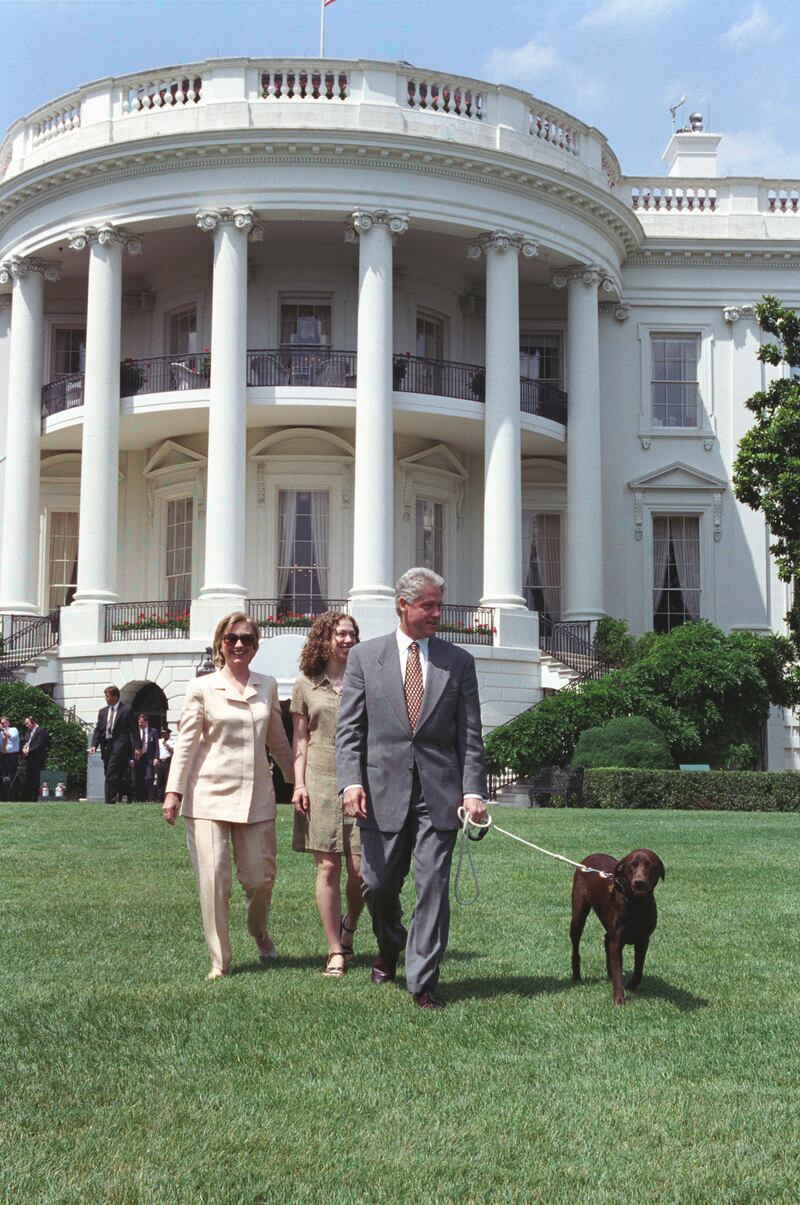 President William Jefferson Clinton, First Lady Hillary Rodham Clinton, and Chelsea Clinton walking pet Buddy the Dog on the South Lawn of the White House, July 24, 1998. Image courtesy National Archives. (Photo via Smith Collection/Gado/Getty Images).