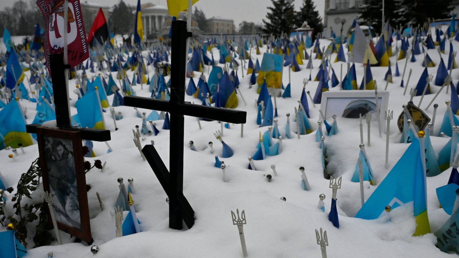Crosses in the snow with Ukrainian flags