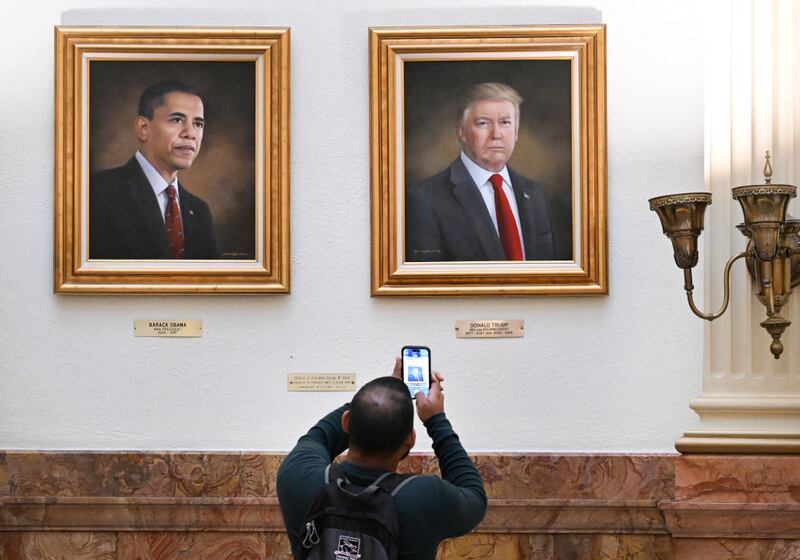 DENVER, CO - MARCH  24: A  visitor takes a picture of the portrait of president Donald Trump, right, that hang on walls in the rotunda on the third floor  of the Colorado State Capitol  in Denver, Colorado on March 24, 2025. The portraits of Presidents Barack Obama, left,  and Donald Trump were painted by Sarah A. Boardman. Boardman painted Trump's portrait in 2019. (Photo by Helen H. Richardson/MediaNews Group/The Denver Post via Getty Images)