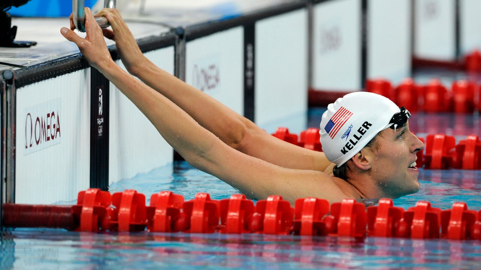 Klete Keller of the USA hangs on the starting block for a while after swimming the anchor leg of the men's 4x200m freestyle relay