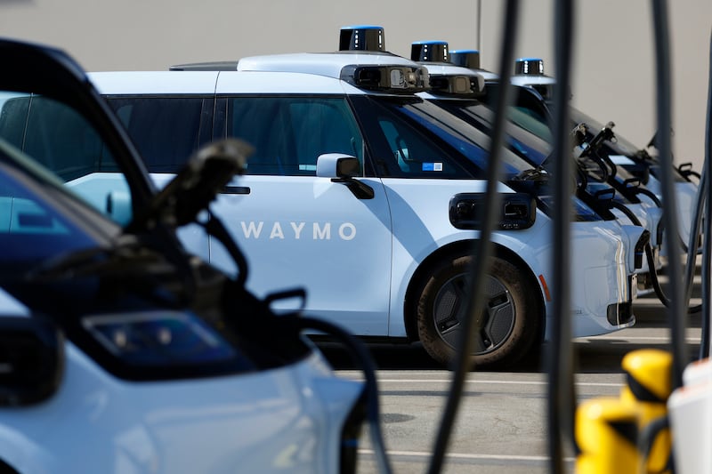 Waymo electric autonomous ride-hailing service vehicles are charged at a private charging station on September 14, 2026 in San Diego, CA.