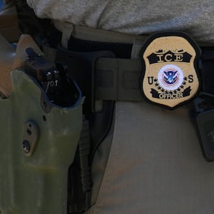 An Immigration and Customs Enforcement (ICE) officer's badge and weapon are seen as ICE conducts a vehicle checkpoint on Georgia Ave.