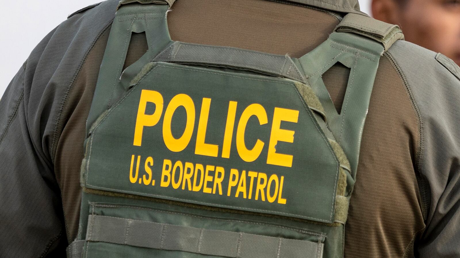 A U.S. Border Patrol agent watches as immigrants prepare to board a bus after crossing the U.S.-Mexico border on January 07, 2024 in Eagle Pass, Texas. According the a new report released by U.S. Department of Homeland Security, some 2.3 million migrants, mostly from families seeking asylum, have been released into the U.S. under the Biden Administration since 2021.