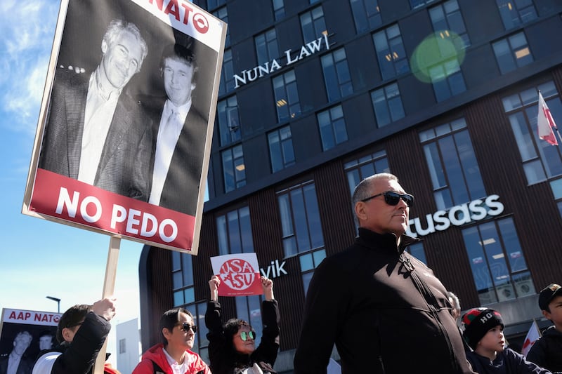 A protester holds a sign that reads 'Yes NATO, No Pedo' with a photo of U.S. President Donald Trump with late sex offender and financier Jeffrey Epstein, on the day of the opening of a new U.S. consulate in Nuuk, Greenland, May 21, 2026.