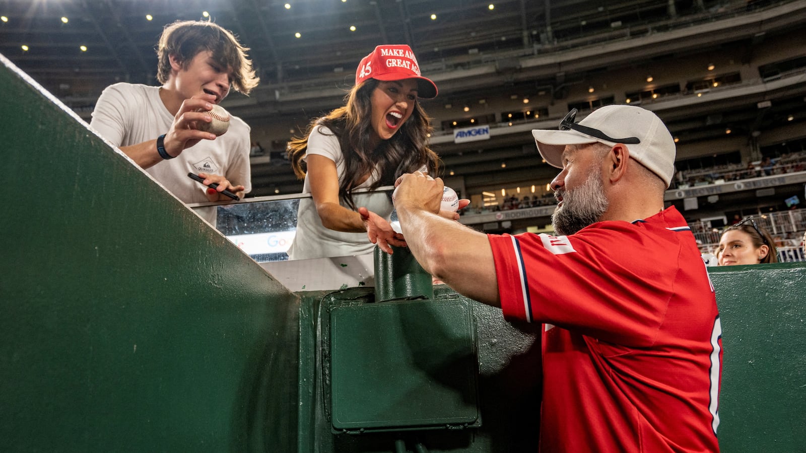 Rep. Lauren Boebert, (R-CO), and her son Brody are given several baseballs by Rep. Cory Mills, (R-FL), during the annual Congressional Baseball Game for Charity at Nationals Park in Washington, U.S., June 12, 2024.