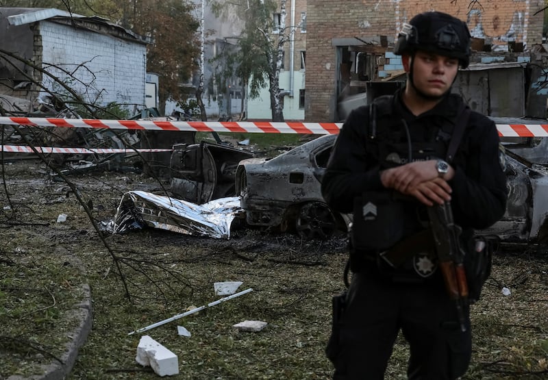 A police officer guards as bodies of residents covered with thermal blanket lie on the ground at a site of a Russian missile strike, amid Russia's attack on Ukraine, in Kyiv, Ukraine September 8, 2026. REUTERS/Stringer
