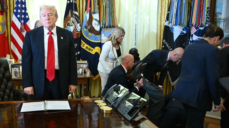 US President Donald Trump looks on after a man fainted during an announcement about weight-loss drugs in the Oval Office of the White House in Washington, DC on November 6, 2025. Trump announced deals Thursday with pharmaceutical giants Eli Lilly and Novo Nordisk to lower the prices of some popular weight-loss drugs. Both companies "have agreed to offer their most popular GLP-1 weight-loss drug," Trump said, "at drastic discounts."
